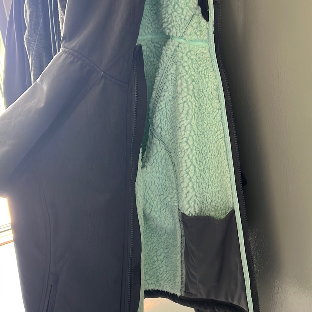 Grey winter jacket with teal fur inside.